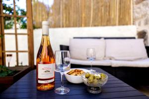 a bottle of wine and two glasses on a table at La Loubière - Gîte in Cessenon