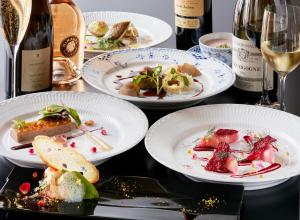 een tafel met borden en flessen wijn bij Hotel Europe Huis Ten Bosch in Sasebo