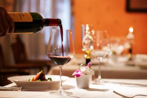 a person pouring wine into a wine glass on a table at Hotel Europe Huis Ten Bosch in Sasebo