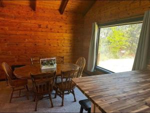 a dining room with a table and chairs and a window at Charming Canyon Cabin in Cedar City