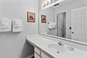 un bagno bianco con lavandino e specchio di True Blue Golf Escape 2 Bdrm 2 Bath a Pawleys Island Altre 12 foto