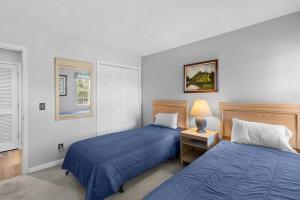 una camera da letto con due letti e un tavolo con una lampada di True Blue Golf Escape 2 Bdrm 2 Bath a Pawleys Island