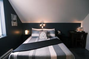 a bedroom with a bed with a black wall at Les Pinsons des Rives in La Malbaie