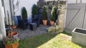 a patio with chairs and potted plants next to a building at Appartements an der Kaiserpfalz - Kaiserpfalz in Forchheim