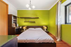 1 dormitorio con paredes verdes y 1 cama grande en Casa Rocha, en Fajã da Ovelha