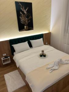 a bedroom with a large white bed with a plate on it at Apartmani BOŽIČKOVIĆ in Palić