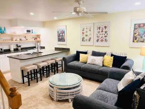 a living room with a couch and a table and a kitchen at Sea Breeze, Beautiful Ocean Front Townhome in Kure Beach