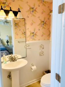 a bathroom with a sink and a mirror and a toilet at Sea Breeze, Beautiful Ocean Front Townhome in Kure Beach +17 photos