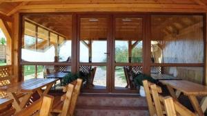 a porch with wooden tables and chairs in a cabin at Salcia Pletoasa in Mahmudia