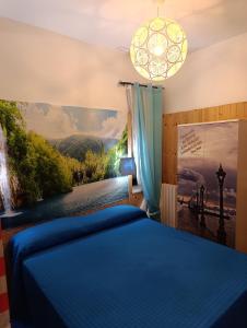 a bedroom with a blue bed and a painting on the wall at Appartamento Nonna Lina in Padenghe sul Garda