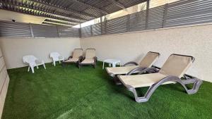 エイラットにあるApartment Eilatの椅子と緑の芝生が備わる待合室