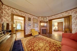 una sala de estar con un sofá y una silla en Historic Victorian Farmhouse with Porch and Views!, en Mayville