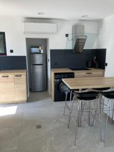 a kitchen with a table and a stove and a refrigerator at Cocon proche de Lyon in Neyron