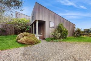 a wooden building with a door and some bushes at Green Vale Getaway - 2 Bed 2 Bath Vacation home in Sea Ranch in Sea Ranch