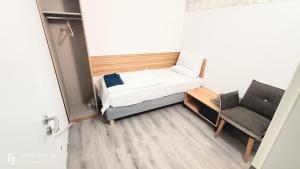 a small room with a bed and a chair at FMI174 Apartment in Neu Isenburg