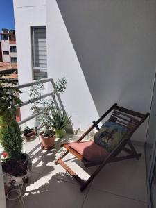 een stoel op een balkon met potplanten bij Habitaciones en alquiler centro de Tarija in Tarija