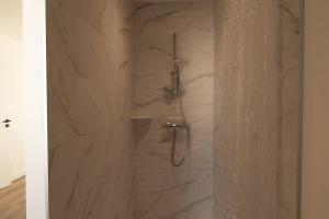 a bathroom with a shower with a stone wall at Maison contemporaine Plescop in Plescop +18 photos
