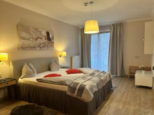 ein Schlafzimmer mit einem großen Bett mit roten Kissen in der Unterkunft Exclusive Holiday Apartments in Villach