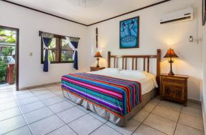 a bedroom with a bed and a table and a window at Splash Inn Dive Resort & Villas in West End