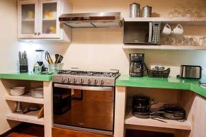 a kitchen with a stove and a microwave at walk to malecón, private Pool and Garden in La Paz