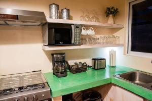 a kitchen with a counter with a microwave and a sink at walk to malecón, private Pool and Garden in La Paz
