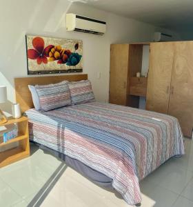 a bedroom with a bed with a striped blanket at Increíbles condominios con vista al mar in Tangolunda +7 photos