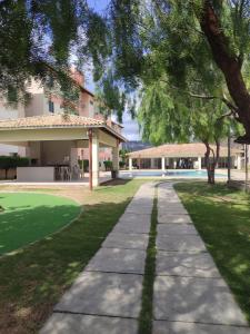 a walkway in front of a house with trees at Apartamento no condomínio Golden Park 2 quartos in Jacobina +9 photos