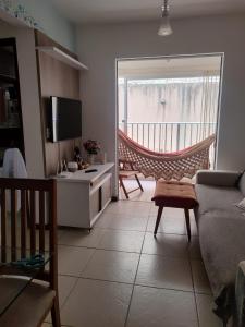 a living room with a couch and a room with a window at Apartamento no condomínio Golden Park 2 quartos in Jacobina
