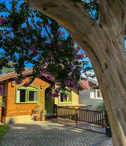 a house with a tree in front of it at Pousada Charm Canela in Canela