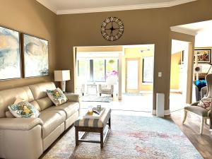 a living room with a couch and a clock on the wall at Sarasota Charm in Sarasota