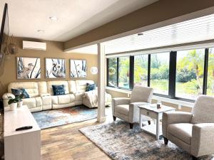 a living room with a couch and chairs and windows at Sarasota Charm in Sarasota