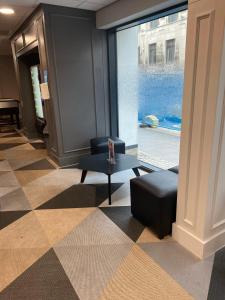 a lobby with a chair and a table and a window at For Students Only Market House in Newcastle in Newcastle upon Tyne