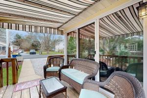a screened porch with wicker chairs and a table at Town of Bethany Beach --- 431 Collins St in Bethany Beach