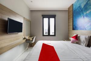 a bedroom with a bed with a tv on the wall at Collection O Bekasi Timur Near Gedung Juang Formerly Regia Tambun in Bekasi