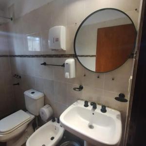 a bathroom with a toilet and a sink and a mirror at Casa CNH 2 in Santiago del Estero