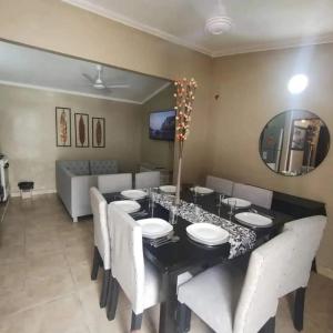 a dining room with a black table and white chairs at Casa CNH 2 in Santiago del Estero