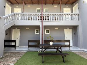 a patio with a bench and a table and stairs at Dom Suites in Agioi Apostoli