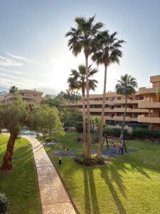 un parco con palme e parco giochi di Paraiso Cala Azul- La Cala de Mijas a La Cala de Mijas
