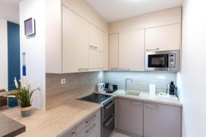 una cucina con mobili bianchi e un lavandino di Sunset Resort 505 a Fonyód