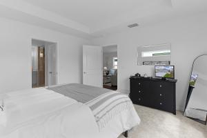 a white bedroom with a bed and a television at Cozy Family Stay- Queen-Double-Twins Bed- Full Kitchen-Netflix-Golf Cart-WiFi in Okahumpka +45 photos
