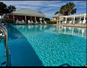 a large pool with blue water in front of a house at Cozy Family Stay- Queen-Double-Twins Bed- Full Kitchen-Netflix-Golf Cart-WiFi in Okahumpka