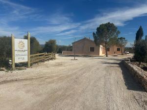 a dirt road in front of a building with a sign at Cortijo Ojos del Prado in Caravaca de la Cruz