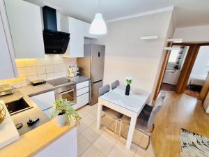eine Küche mit einem kleinen weißen Tisch und Stühlen in der Unterkunft Apartman Lana in Stobreč