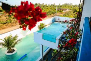 a view of a swimming pool on a balcony with flowers at Pousada La Grécia in Camocim