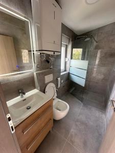 een badkamer met een wit toilet en een wastafel bij Apartman Little Dream in Split