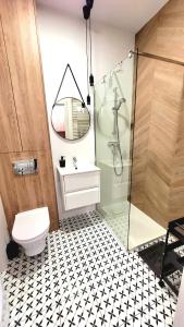 a bathroom with a shower and a toilet and a sink at Apartament Nowoczesny Fordon in Bydgoszcz +13 photos