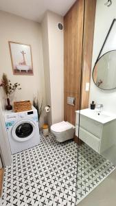 a bathroom with a washing machine and a sink at Apartament Nowoczesny Fordon in Bydgoszcz