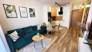 a living room with a green couch and a table at Apartament Nowoczesny Fordon in Bydgoszcz