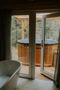 a bathroom with a tub next to a window at Domki pod Halą Krupową - Tiny House w Lesie in Sidzina