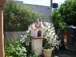 a small bird house in a garden with flowers at Xenos Apartments in Keratokampos